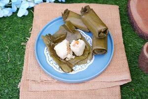 Arem-arem, a traditional food made from rice filled with vegetables, chicken, meat or tempeh wrapped in banana leaves. Arem-arem is popular as a breakfast substitute photo