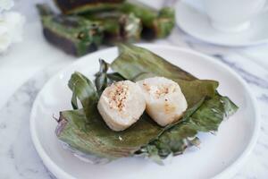 lemper bakar. lemper es un tradicional indonesio bocadillo hecho de glutinoso arroz y lleno con pollo carne y envuelto en plátano hojas. selectivo atención foto