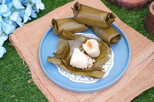 Arem-arem, a traditional food made from rice filled with vegetables, chicken, meat or tempeh wrapped in banana leaves. Arem-arem is popular as a breakfast substitute photo