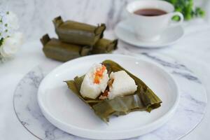 Arem-arem, a traditional food made from rice filled with vegetables, chicken, meat or tempeh wrapped in banana leaves. Arem-arem is popular as a breakfast substitute photo