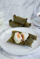 Arem-arem, a traditional food made from rice filled with vegetables, chicken, meat or tempeh wrapped in banana leaves. Arem-arem is popular as a breakfast substitute photo
