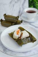 Arem-arem, a traditional food made from rice filled with vegetables, chicken, meat or tempeh wrapped in banana leaves. Arem-arem is popular as a breakfast substitute photo