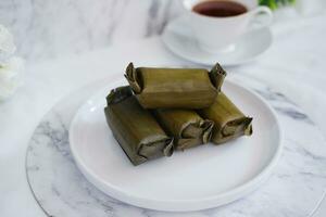 Arem-arem, a traditional food made from rice filled with vegetables, chicken, meat or tempeh wrapped in banana leaves. Arem-arem is popular as a breakfast substitute photo