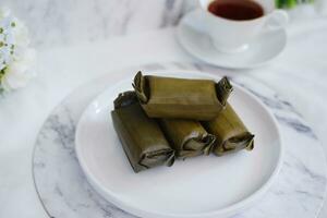 Arem-arem, a traditional food made from rice filled with vegetables, chicken, meat or tempeh wrapped in banana leaves. Arem-arem is popular as a breakfast substitute photo