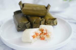 Arem-arem, a traditional food made from rice filled with vegetables, chicken, meat or tempeh wrapped in banana leaves. Arem-arem is popular as a breakfast substitute photo