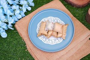Lepet or Leupeut is a type of snack made from glutinous rice mixed with peanuts, cooked in coconut milk, then wrapped in coconut leaves. Close up view photo