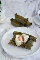 Arem-arem, a traditional food made from rice filled with vegetables, chicken, meat or tempeh wrapped in banana leaves. Arem-arem is popular as a breakfast substitute photo