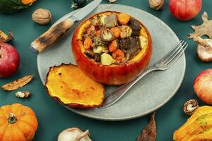 Tasty baked pumpkin with beef, mushrooms and apples. photo