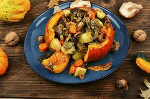 Tasty baked pumpkin with beef, mushrooms and apples. photo