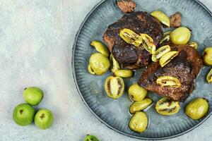 Grilled ostrich steak with kiwi berries photo