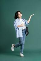 Portrait of a beautiful Asian student on a green background photo