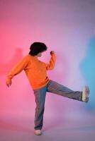 imagen de un joven asiático persona bailando en un neón de colores antecedentes foto