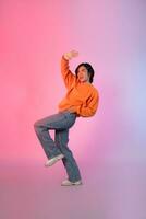 imagen de un joven asiático persona bailando en un neón de colores antecedentes foto