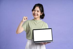 Portrait of beautiful asian woman posing on purple background photo