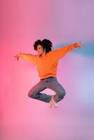 Image of a young Asian person dancing on a neon colored background photo