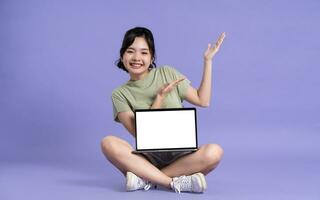 Portrait of beautiful asian woman posing on purple background photo