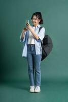 Portrait of a beautiful Asian student on a green background photo