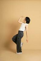 Image of Asian dancer dancing on beige background photo