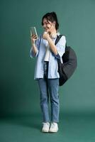 Portrait of a beautiful Asian student on a green background photo