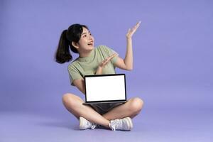 Portrait of beautiful asian woman posing on purple background photo