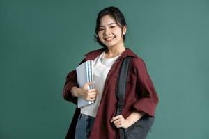 Portrait of a beautiful Asian student on a green background photo