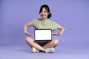 Portrait of beautiful asian woman posing on purple background photo