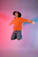 Image of a young Asian person dancing on a neon colored background photo