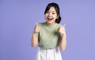 Portrait of beautiful Asian girl posing on purple background photo