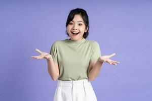 Portrait of beautiful Asian girl posing on purple background photo