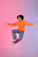 Image of a young Asian person dancing on a neon colored background photo