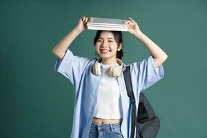 retrato de un hermosa asiático estudiante en un verde antecedentes foto