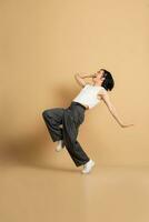 Image of Asian dancer dancing on beige background photo