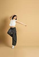 Image of Asian dancer dancing on beige background photo
