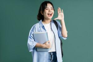 retrato de un hermosa asiático estudiante en un verde antecedentes foto