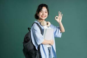 retrato de un hermosa asiático estudiante en un verde antecedentes foto