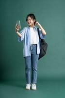 retrato de un hermosa asiático estudiante en un verde antecedentes foto