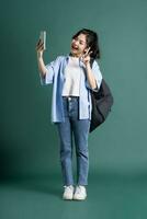 Portrait of a beautiful Asian student on a green background photo