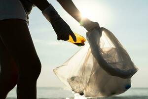 Save water. Volunteer pick up trash garbage at the beach and plastic bottles are difficult decompose prevent harm aquatic life. Earth, Environment, Greening planet, reduce global warming, Save world photo