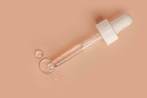 cosmetic gel smeared on a beige background with a pipette and drops of gel photo