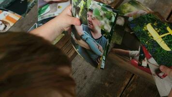 Photo printing, family memories. Preschooler boy looking at printed photos. video