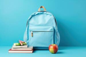 Blue school backpack with books and apple on blue background. Back to school concept, Stationery set with knapsack on blue background, AI Generated photo