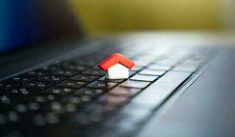 House on a computer keyboard. Paying bills online. House and utilities. Electricity, heating, water and gas. Energy efficiency. Electronic documentation in registers. Registration of property. photo