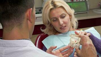 atraente maduro mulher falando para a dentista às dele escritório video