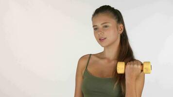 Young woman lifting dumbbells, working out isolated on white video