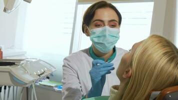 Female dentist working, examining teeth of a patient at the clinic video