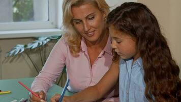 contento hermosa hembra profesor sonriente mientras Ayudar su adorable pequeño estudiante video