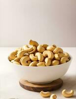 Roasted cashew nuts in a bowl with a white background by AI generated. photo