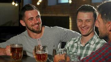 grupo de masculino amigos tintinamente cerveza lentes y Bebiendo a el bar video