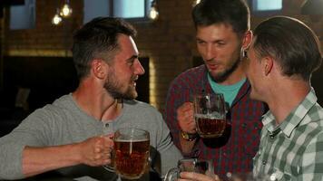 Group of friends smiling to the camera holding up their beer glasses at the bar video