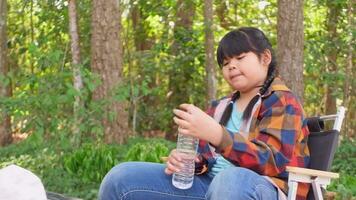 asiatique fille séance en dessous de le arbre souriant Heureusement video